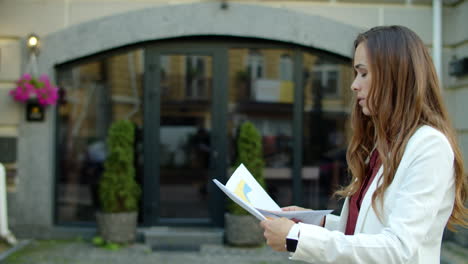 businesswoman reading documents outdoors