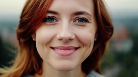 retrato de una mujer sonriente con cabello rojo y ojos verdes