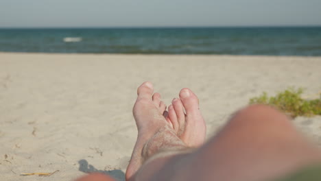 relaxing beach scene with sandy feet and ocean horizon