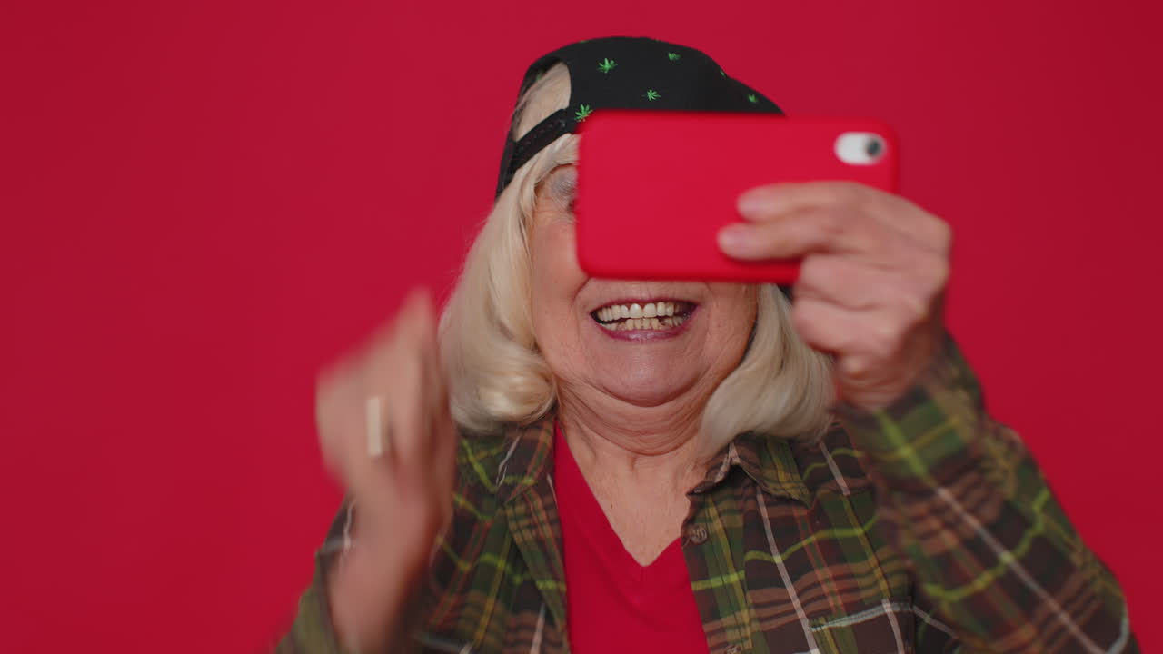 mujer mayor preocupada, divertida y adicta juega con entusiasmo a videojuegos de carreras en su teléfono móvil