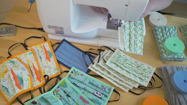 Woman sewing face mask in various colorful kids designs