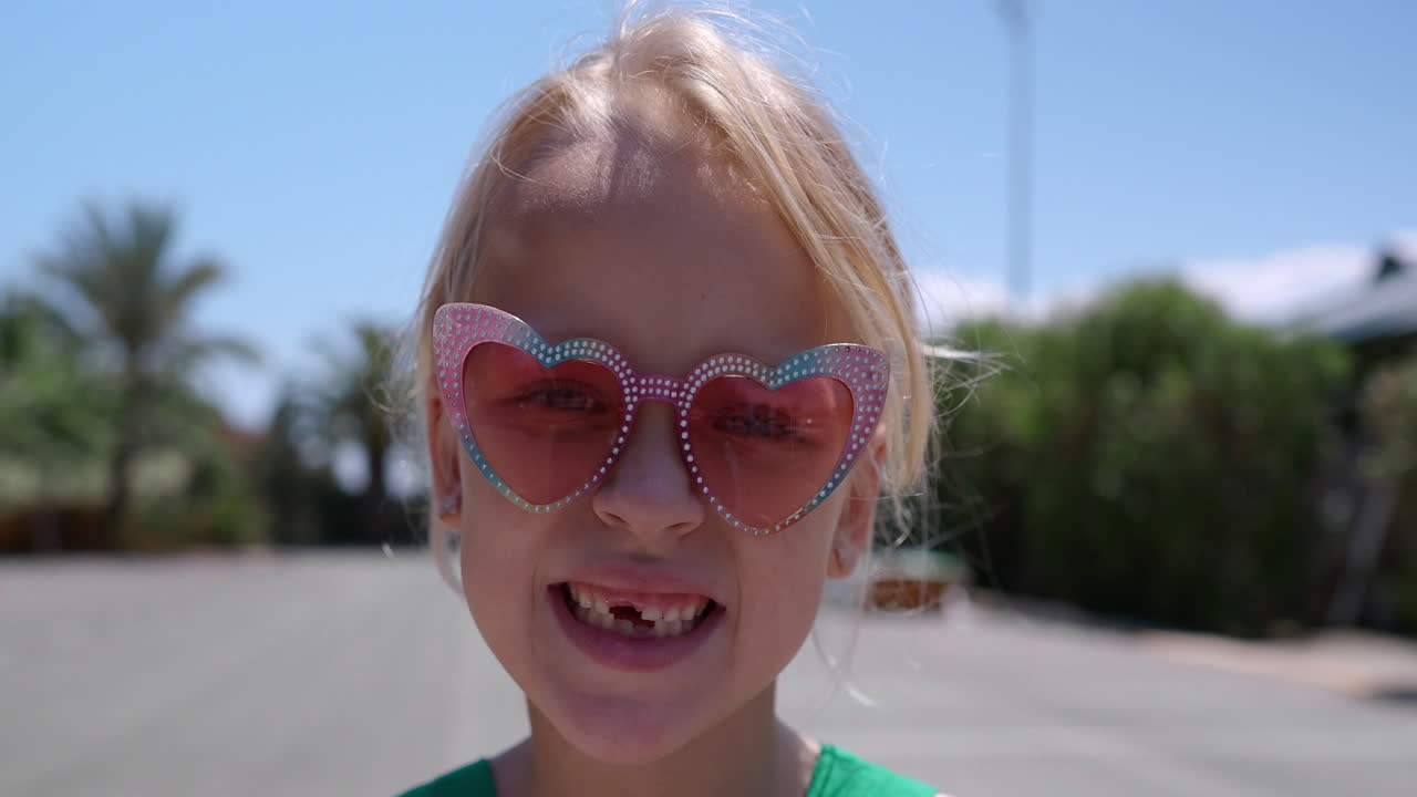 chica sonriente con gafas de sol rosas