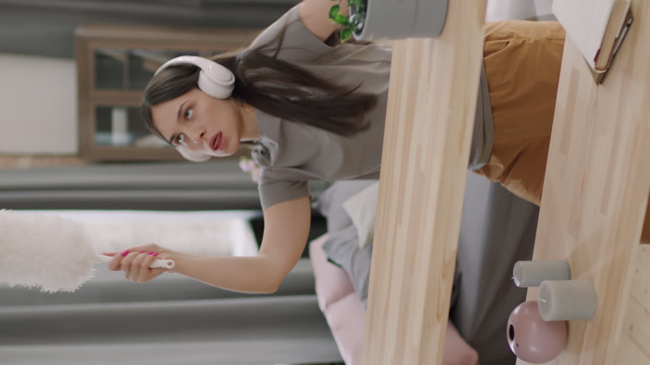 Vertical Shot of Woman Cleaning and Dancing to Music