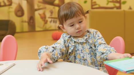 linda niñita hojeando un libro en el museo infantil de gyeonggi en corea del sur - cámara lenta