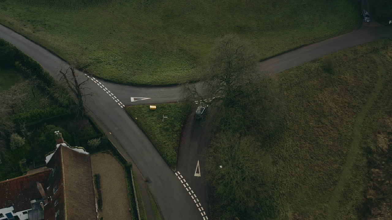 Aerial drone shot following a car driving pass country homes