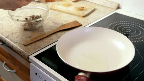 close-up man's hands makes cutlets and fries it on the frying pan.