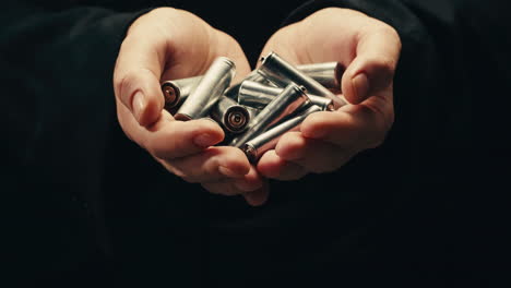 silver batteries aa and aaa in hands on black background close-up. double-a battery is a standard size single cell cylindrical dry battery. batteries are common in portable electronic devices. an aa battery is composed of a single electrochemical cell that may be either a primary battery or a rechar