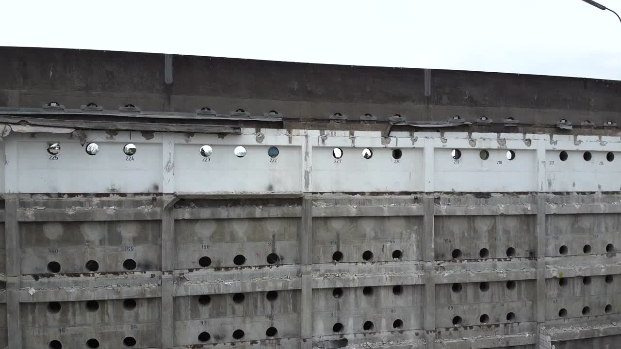 독일, 유럽의 구름이 가득한 하늘 아래의 도시의 풍경과 함께 오래된 주차장의 자갈과 잔해 위로 상승하는 드론 영상