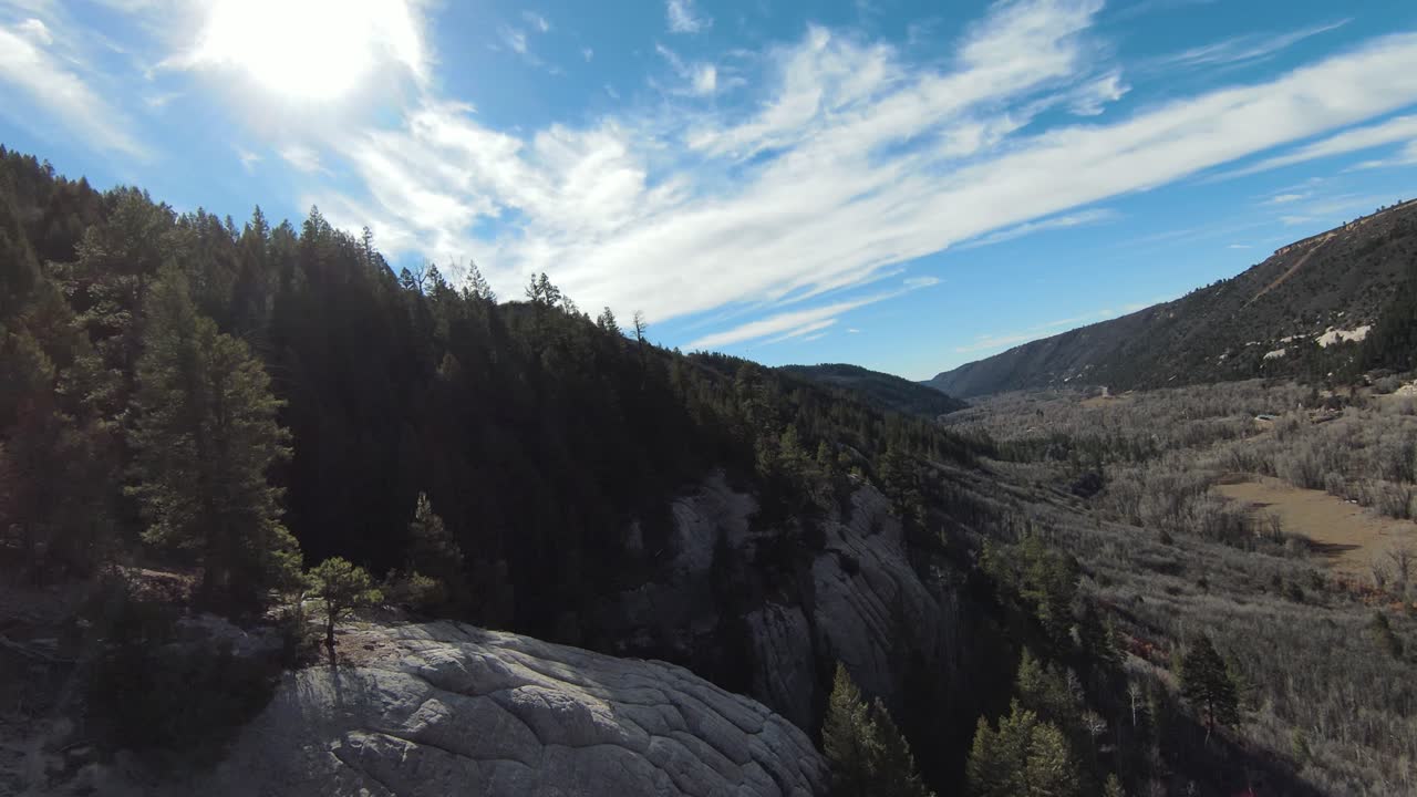 FPV Drone along mountains with lens flare