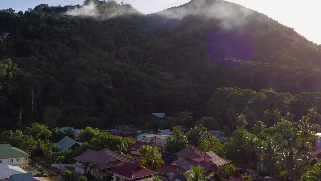 columnas de humo se elevan desde el bosque en una montañosa isla tropical en las seychelles, insinuando posibles incendios forestales