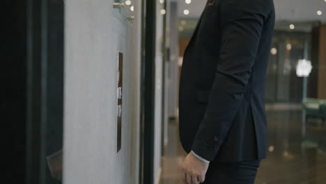 businessman waiting for elevator in hotel lobby