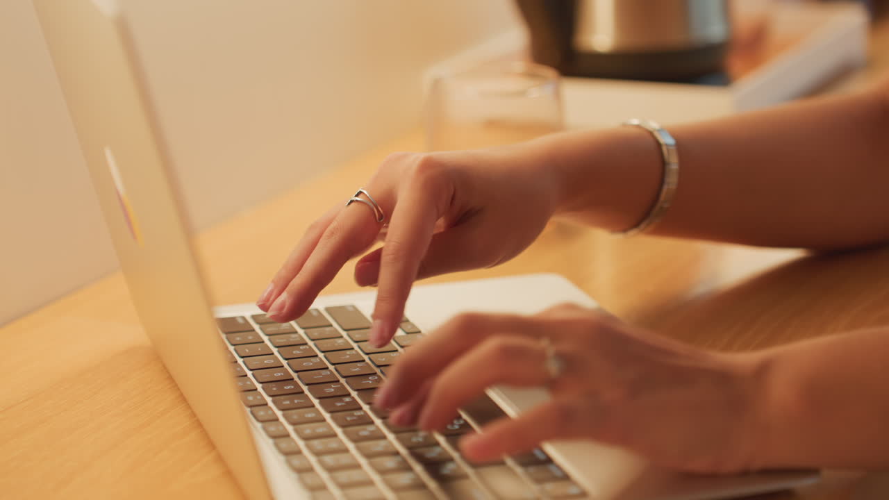 Focused woman editing at hotel. Woman concentrating on computer work at hotel room desk during night hours. Dedicated woman editing document at hotel desk under lamp light during evening hours