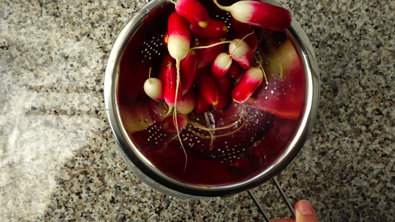 Lancio di un ravanello da giardino in uno scolapasta. Rallentatore