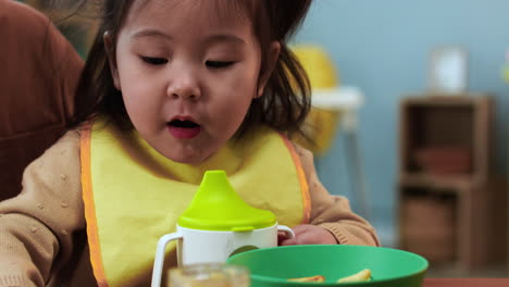 unrecognizable woman sitting at a table with her baby