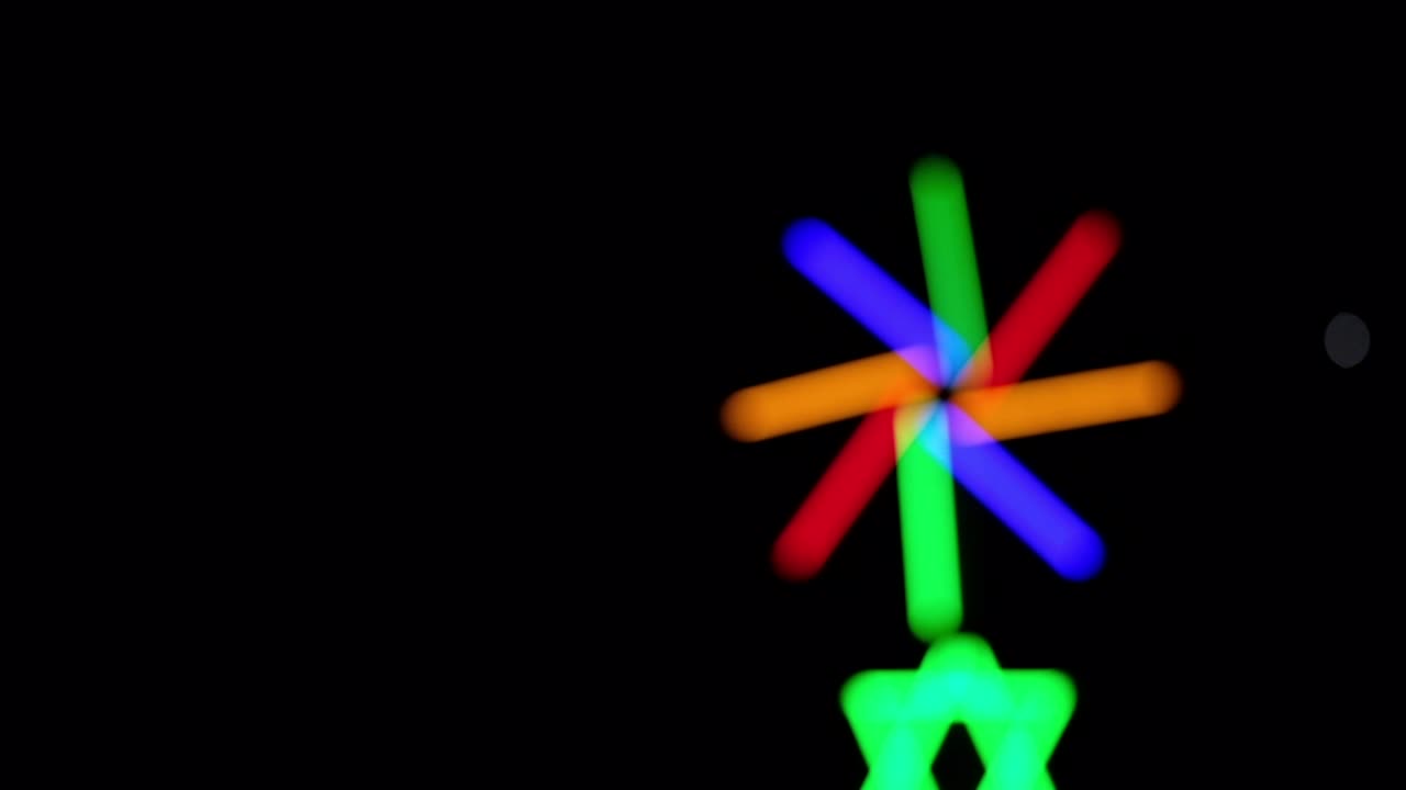 Slørede farverige lysstråler fra fluorescerende lys på en festivalnatbaggrund