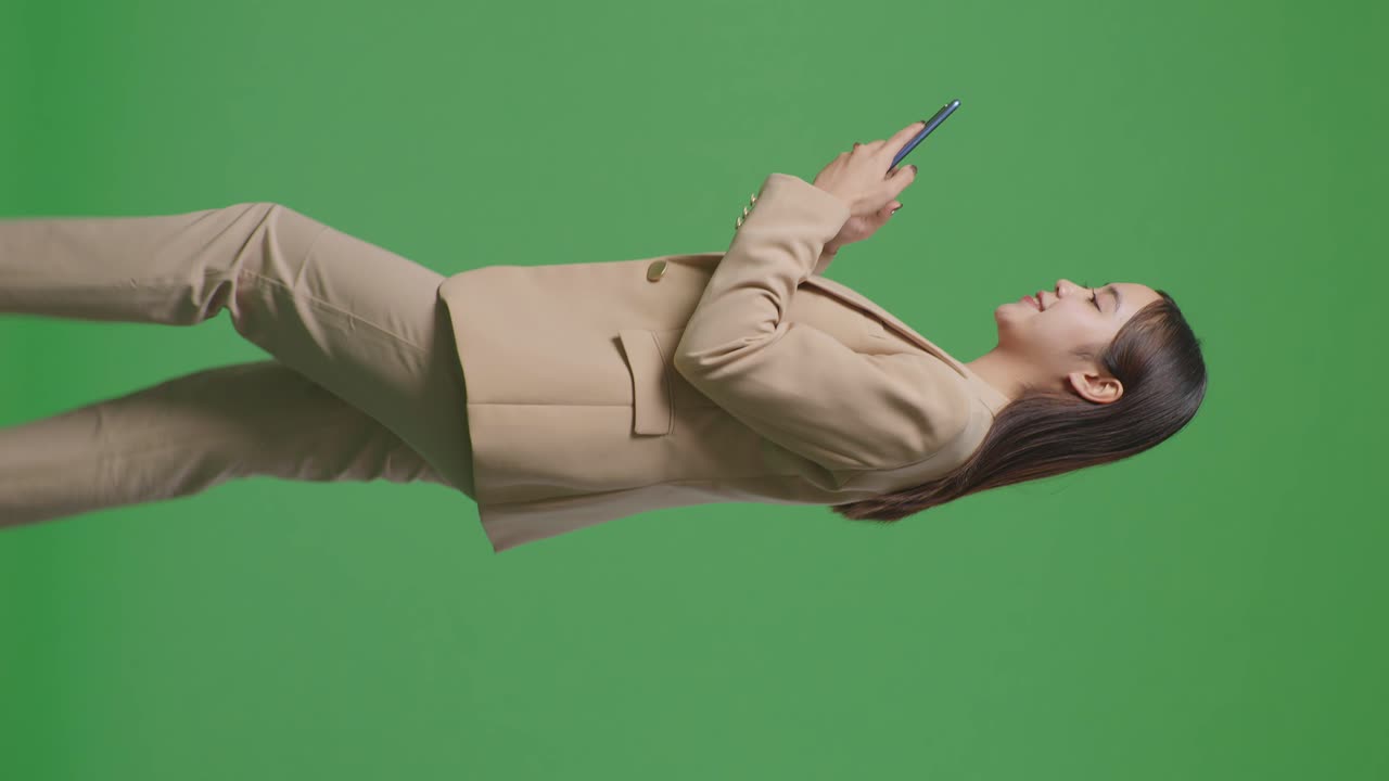 아시아 사업가 여성의 측면 뷰 휴대전화를 사용하고 녹색 화면에서 는 크로마 키