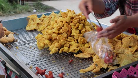 people seasoning and frying snacks on outdoor grill