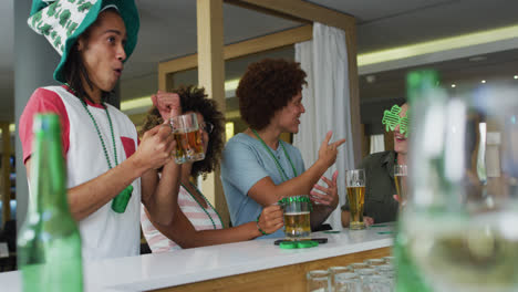 diverse group of happy friends celebrating st patrick's day drinking beers at a bar