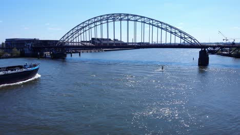 Steel-Arch-Bridge-Over-Noord-River-With-Sailing-Vessel-At-Daytime-Near-Hendrik-Ido-Ambacht,-Netherlands