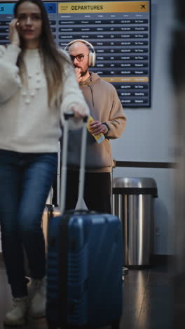 man at airport with suitcase and snacks