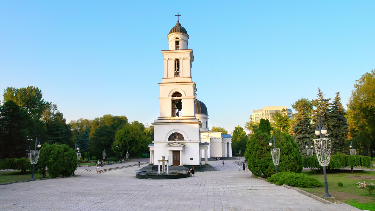 Aerial drone view of Chisinau downtown at sunset. Central park, Cathedral, bell tower, a lot of greenery, walking people. Moldova