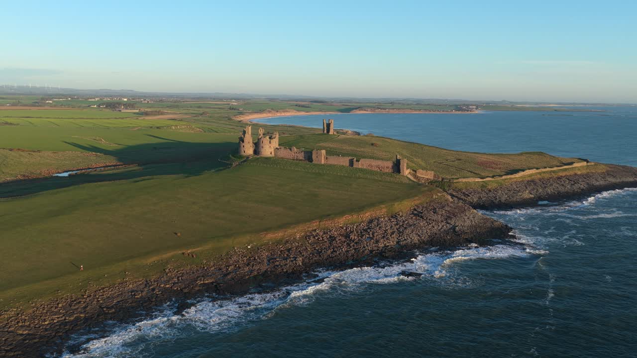 Rovine del castello di Dunstanburgh sulla costa del Northumberland all'alba