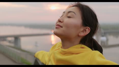 woman enjoying sunrise/sunset over a river