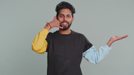 Bearded-indian-man-looking-at-camera-doing-phone-gesture-like-says-hey-you-call-me-back-conversation