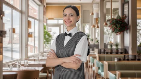 portrait of happy indian woman waiter standing crossed hands