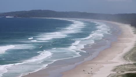 a tranquil beach scene with waves and visitors