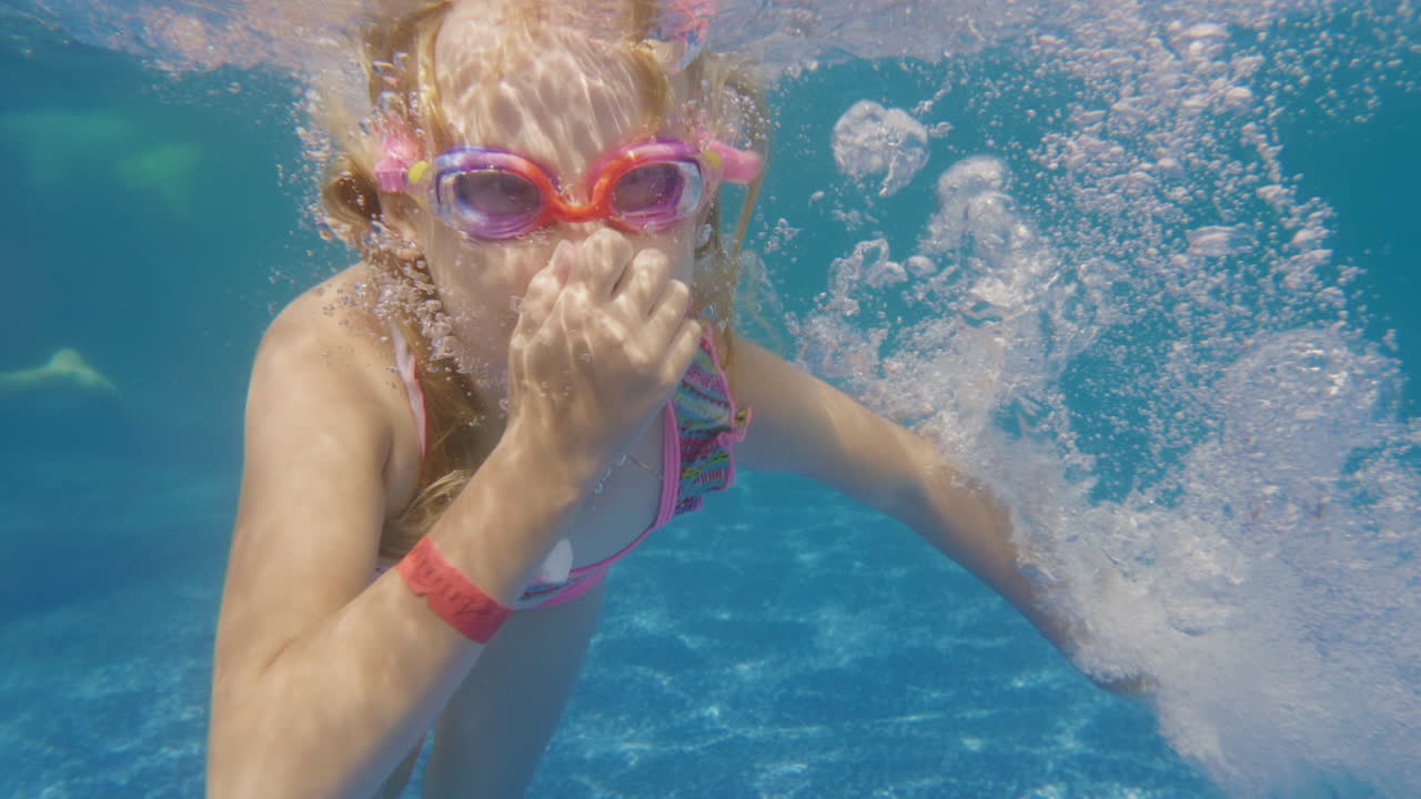 6세 소녀는 수영장 슬로우 모션 비디오에서 다이빙하는 법을 배웁니다.