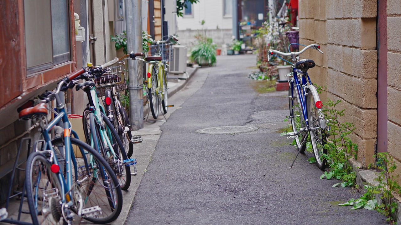 Several bikes lean against aged walls in a quiet backstreet, showing a glimpse of daily local life and urban neighborhood atmosphere.