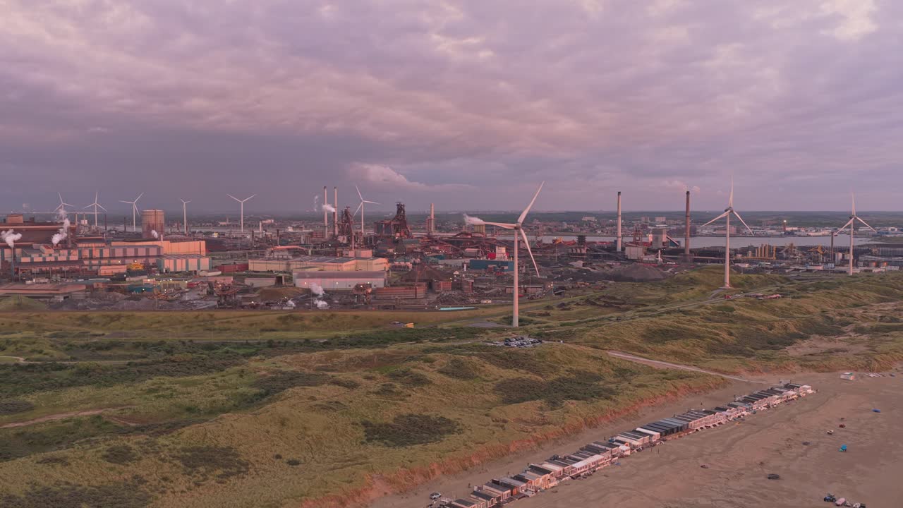 Spiaggia di Wijk aan Zee con dune e industria siderurgica sullo sfondo, Paesi Bassi.