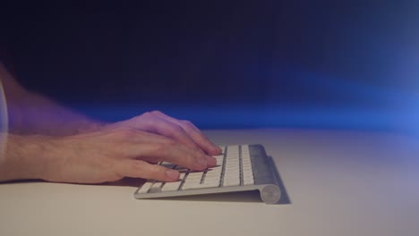 Working-from-home-male-hands-typing-on-a-keyboard-with-cinematic-lens-flare