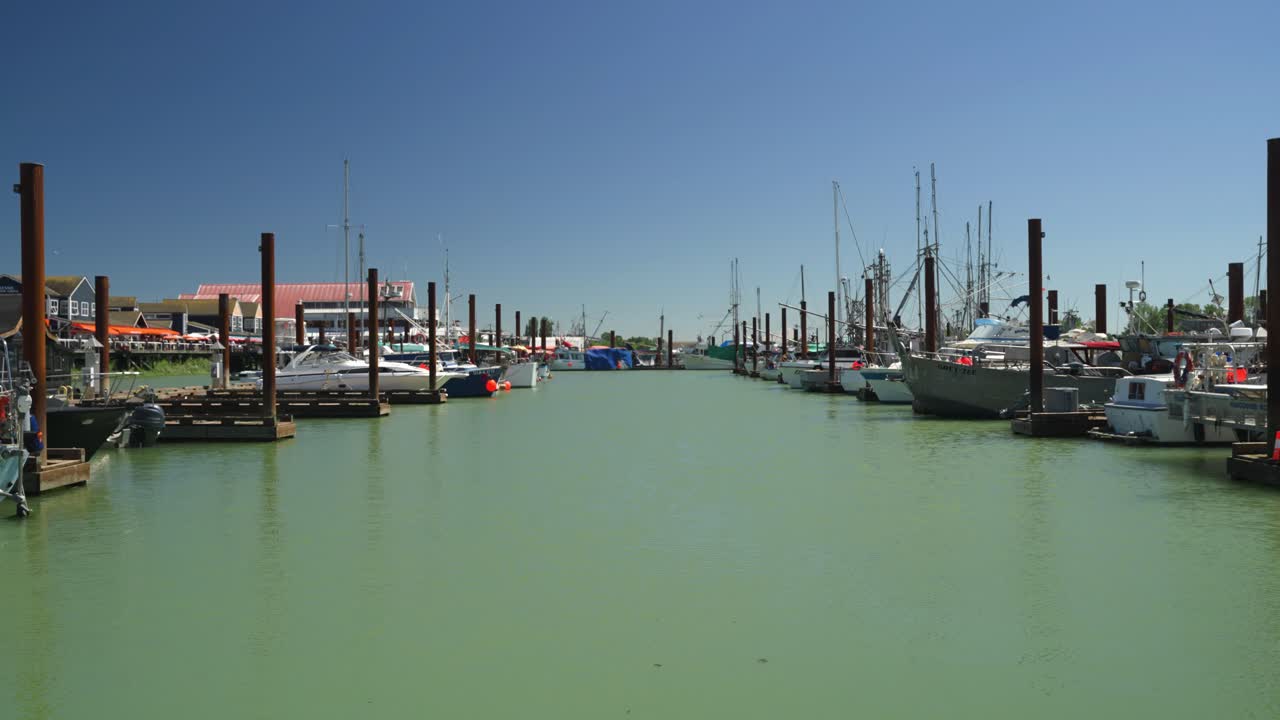 fotografía estática de mano mirando hacia el puerto deportivo en un pequeño pueblo pesquero local, steveston, canadá