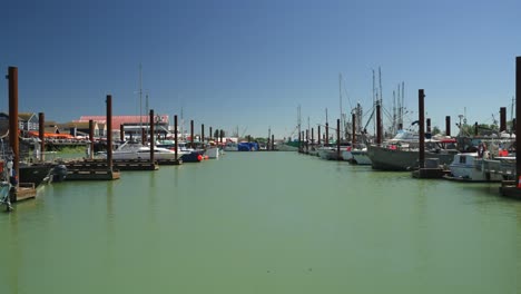 static handheld shot looking down the marina in a small local fishing village, steveston, canada