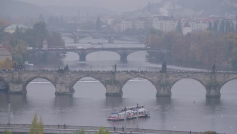 wide shot capturing the beautiful bridges in prague on a foggy day