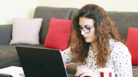 profesor tomando notas y trabajando desde casa en una laptop comunicándose en línea con los alumnos después del brote de coronavirus en europa