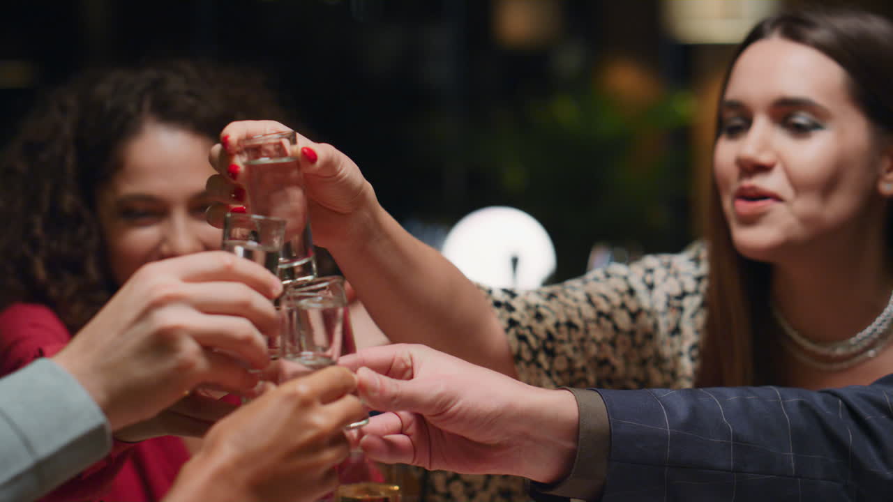 술집에서 술을 마시는 재미있는 그룹. 다민족 친구들이 카페에서 휴식을 취하고 축하합니다.