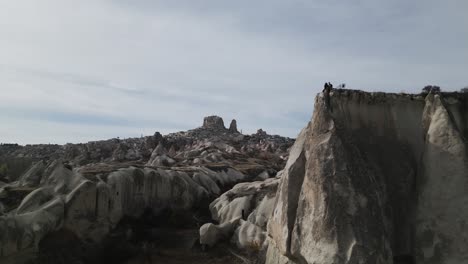gente en la cima de la formación rocosa con vistas al valle de las palomas en uchisar, capadocia, turquía