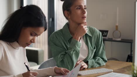 dos mujeres trabajando y analizando algo en la computadora en casa