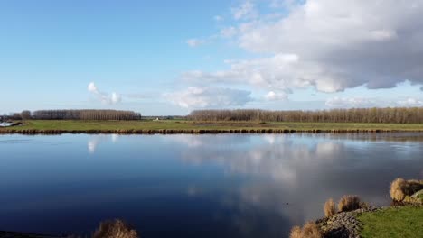 Drone-footage,-a-right-turn-over-the-tidal-river-Het-Spui-in-Holland-with-calm-and-clear-weather