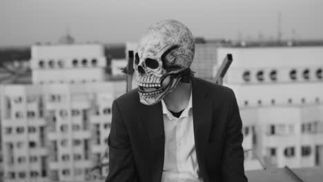 person in a skull mask on a rooftop