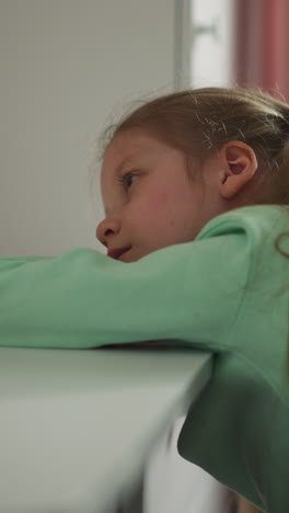 niña triste descansa mientras hace la tarea en el escritorio en la habitación de los niños. escolar cansada yace en la mesa procrastinando tareas aburridas finalización en casa