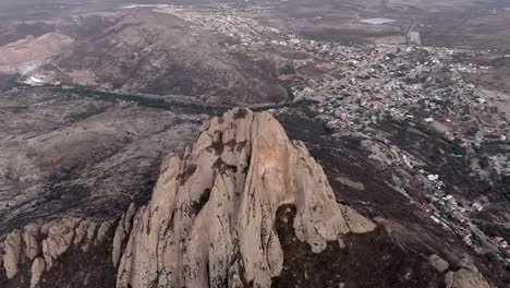 Pena-de-Bernal-Towering-Above-Pueblo-Magico-Town-Of-San-Sebastian-Bernal-In-Queretaro,-Mexico