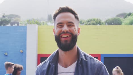 retrato de un feliz maestro caucásico con un grupo feliz y diverso de niños en el fondo