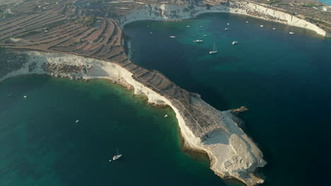 Cabo-Mediterráneo-De-La-Isla-De-Malta-A-La-Luz-Del-Atardecer-Con-Agua-Azul-Turquesa,-Tobogán-Aéreo-A-La-Derecha