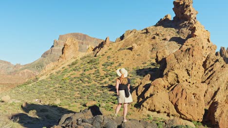 Mujer-Turista-Con-Sombrero-De-Verano-Inmersa-En-El-Paisaje-Rocoso-Del-Parque-Nacional-Del-Teide