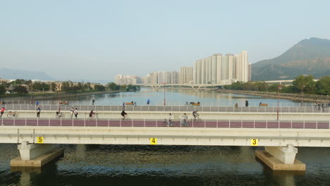impresionante toma panorámica con drones de ciclistas cruzando un puente al atardecer