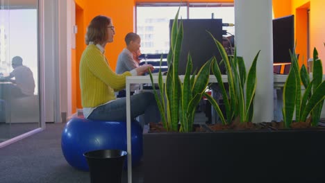 vista lateral de un joven equipo de negocios de raza mixta trabajando juntos en un escritorio en una oficina moderna 4k
